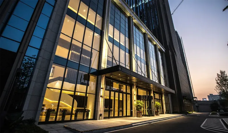 A modern office building lit at dusk