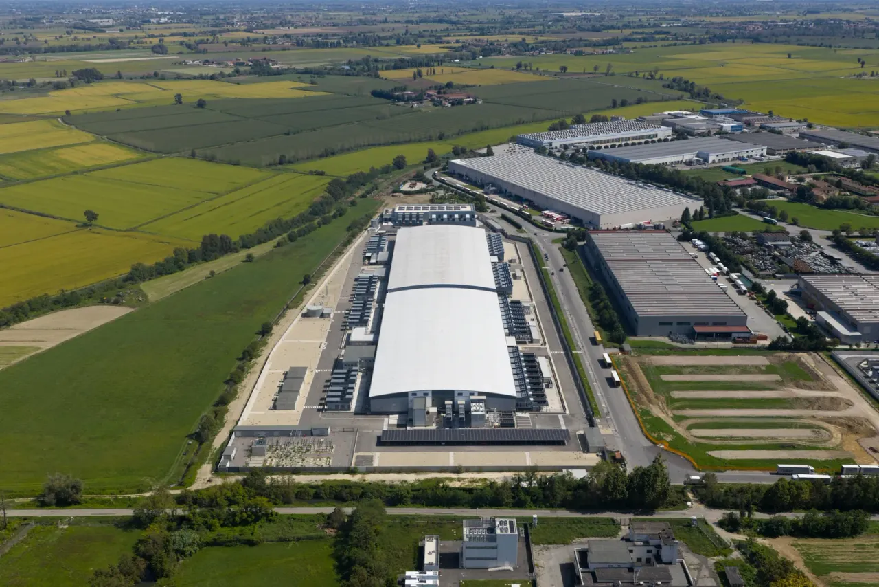 An aerial view of a large data center campus with long white-roofed buildings among farm fields, the kind of setting technology and data center cleaning services programs are built around