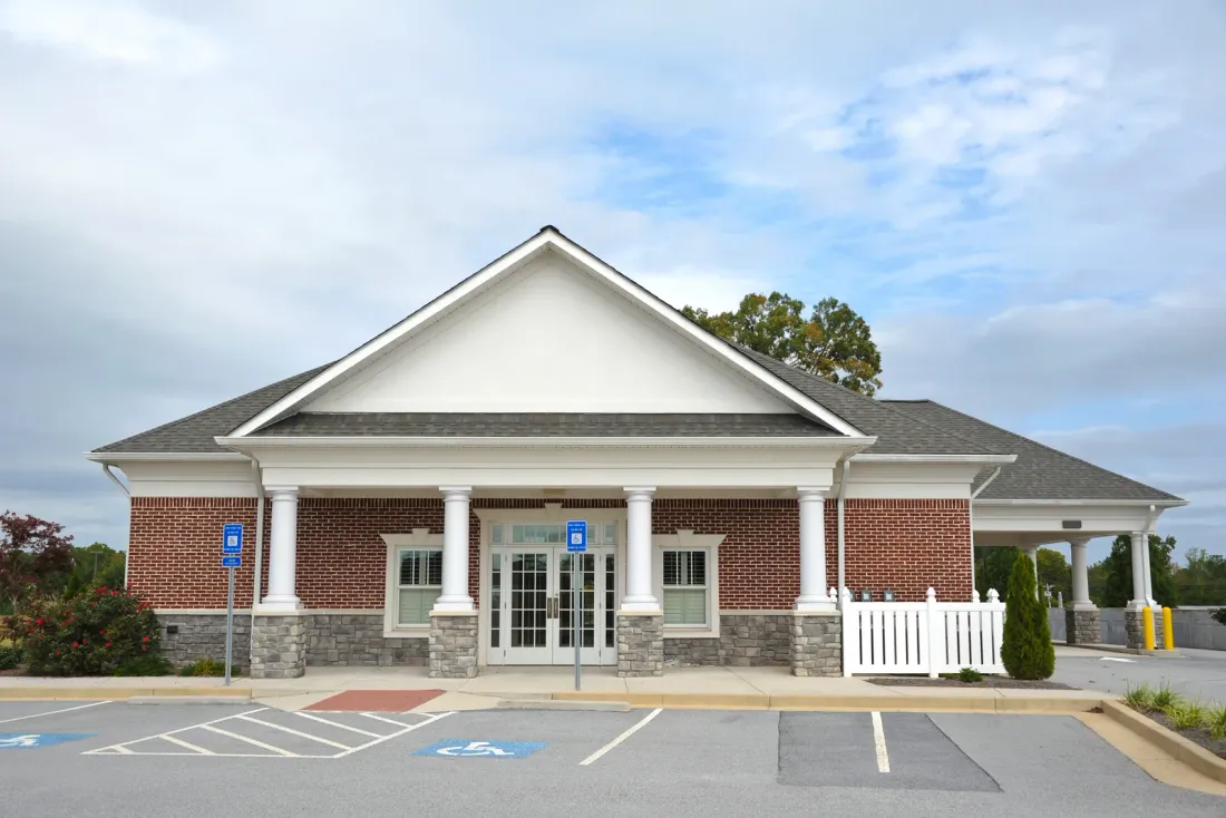 A single-storey brick building with a white columned portico and accessible parking spaces in front, the kind of workspace covered by office cleaning in Pasadena, CA