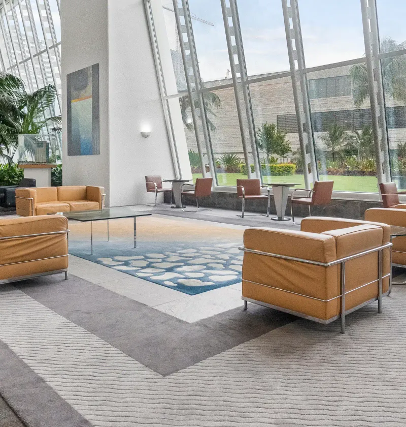 A bright office lobby with tan leather sofas, cleaned and ready for the day