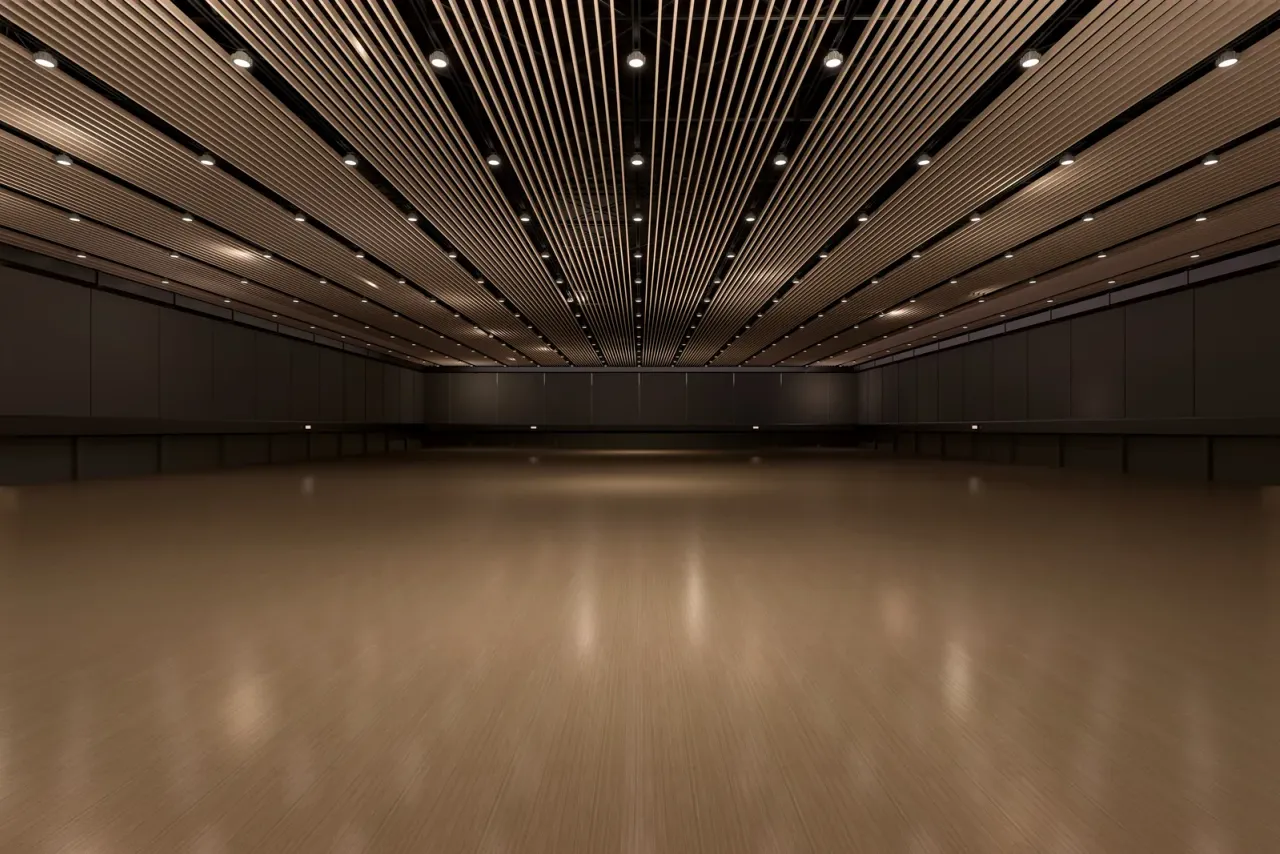 An empty, dimly lit exhibition hall with a polished wood floor and rows of small ceiling lights, illustrating museum and gallery cleaning in Orange County