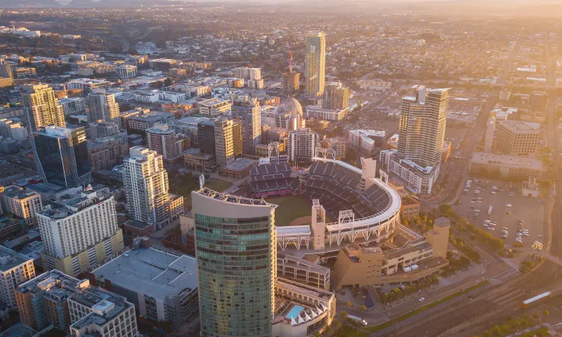 An aerial view of a stadium and the city around it at sunset